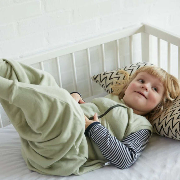 Child wearing Tyngdeposen® Junior weighted sleep sack lying in crib, promoting calming sleep.